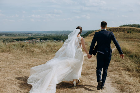 couple in love wedding together outside field path landscape sky veil wind freedom