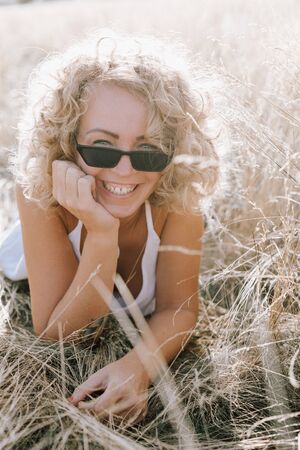 woman curly hairstyle outside field freedom sunset nature open spaceの写真素材