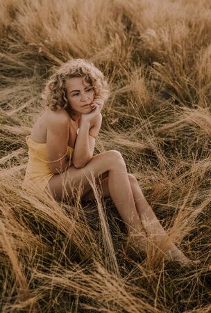 woman curly hairstyle outside field freedom sunset nature open spaceの写真素材