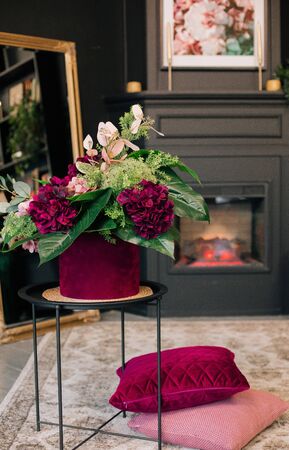 beautiful flowers inside black style fireplace and floral pictureの写真素材