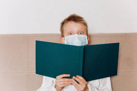 reading book masked school textbook information entertainment leisure virus mode child health home isolation quarantineの写真素材