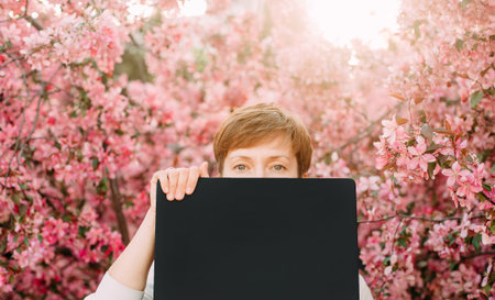 woman looking eyes notebook on sakura blossom pink background