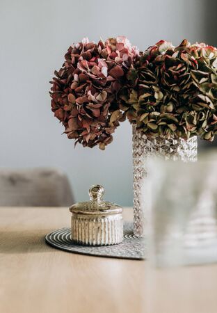 decorative flowers in a glass vase on a table inside a houseの写真素材