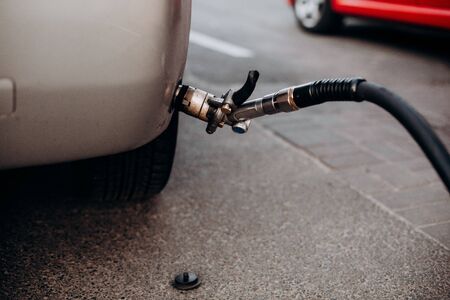 refueling gray car gas gun connection in bumperの写真素材