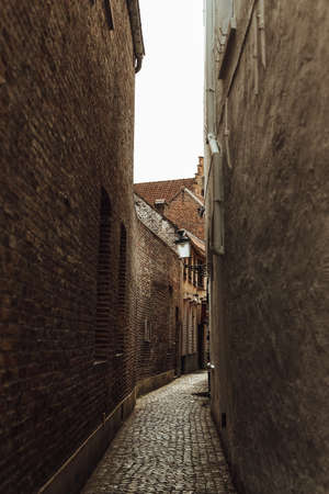 narrow street old town of europe stone winding road and walls of buildingsの写真素材
