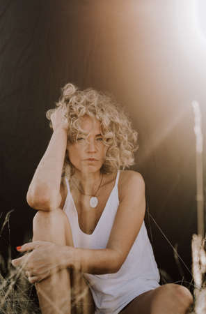woman curly hairstyle outside field freedom sunset nature open spaceの写真素材