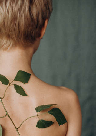 body of a woman with a branch of vegetation conceptual human life renaissance union with natureの写真素材