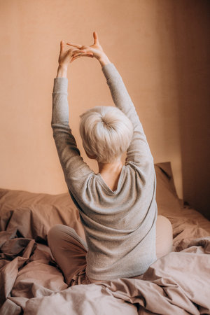 woman blonde inside bedroom morning relax wake up bed and pajamas
