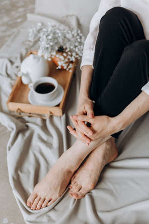 morning relaxation woman in bed tray with tea and flowers relaxing weekendの写真素材