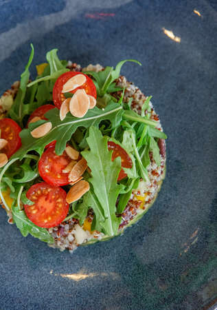 quinoa with vegetables healthy vegetarian food tomato arugula peanuts avocado orangeの写真素材