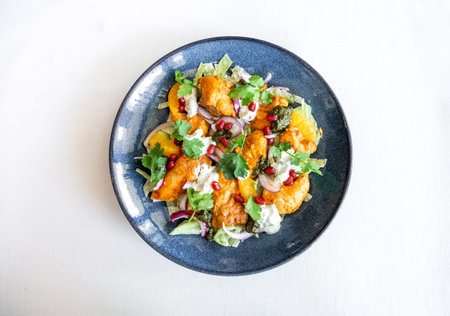 restaurant dish fried chicken fillet with onions sprinkled with pomegranate seeds pesto and tartar...