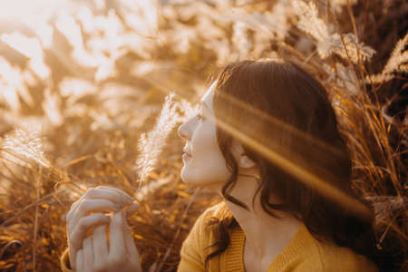 girl with warm autumn sun rays yellow beautiful sunset tenderness conceptualの写真素材