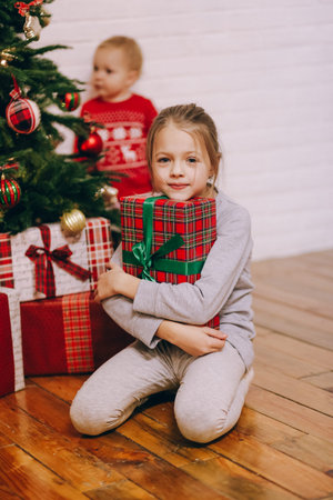 happy girls sisters with christmas gifts from santa home family holiday