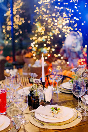 festive large table decorated with christmas symbols candles sparkle party celebration luxury hallの写真素材