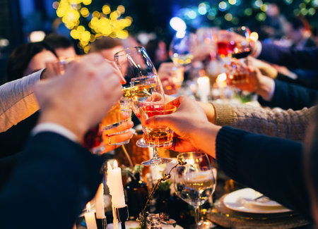 group of people with glasses raise a toast celebrate christmas celebrations against the background of colorful garlandsの写真素材