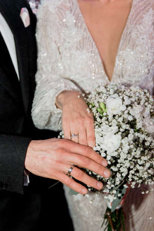bride and groom hands together love wedding tradition with ringsの写真素材