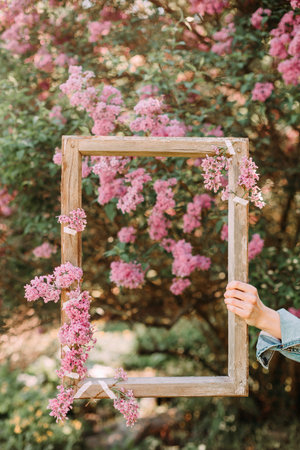 wooden frame for the inscription outside on the background of summer flowering