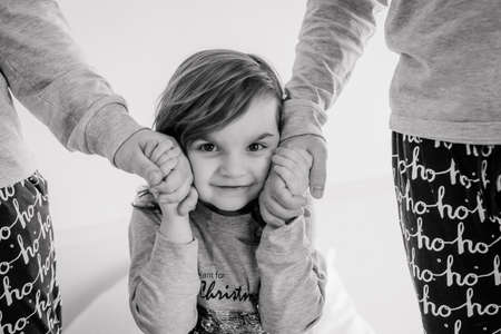 christmas family card child holding parents hands inside conceptual clothesの写真素材