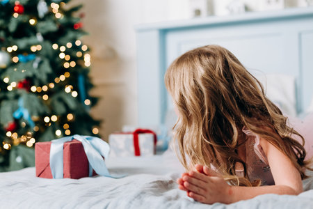 girls choose gifts boxes near christmas tree joy surpriseの写真素材
