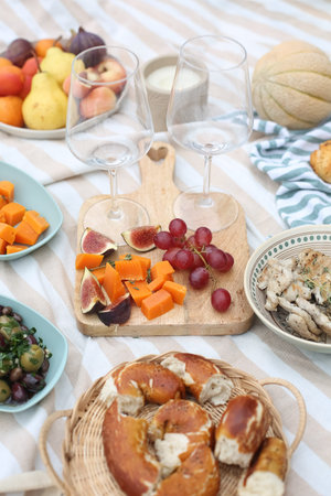 Outdoor Picnic with Wine and Fresh Fruits picnic blanket with a glass of rosÃ© wine, surrounded by...