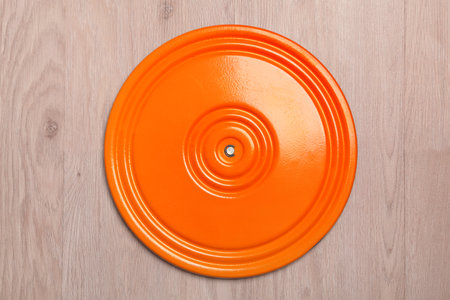 Sports, orange disc to the waist. Metal sports equipment for rotations. Women's health. Top view on wooden floor.の写真素材