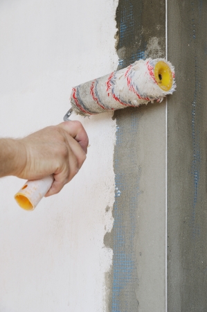 Close-up of construction worker primed the walls of the rollerの写真素材