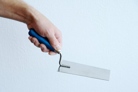 Human hand with a trowel on a white backgroundの写真素材
