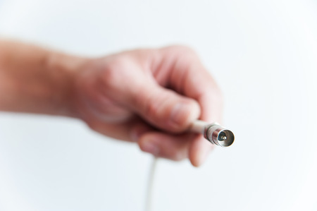 Close-up of a human hand with coaxial cable on a white backgroundの写真素材