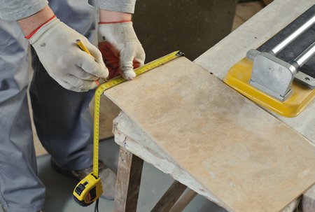 Laying Ceramic Tiles. Tiler measures the tile cuttingの写真素材