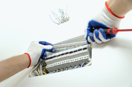 Electrician installing an electrical fuse box in a house.の写真素材
