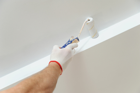 Painting the ceiling and walls. Hand holding a roller.の写真素材