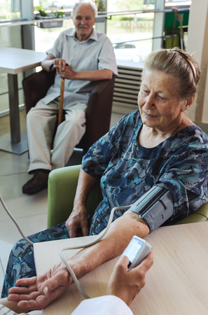 Measuring blood pressure. Old woman at the doctorの写真素材