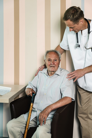 An elderly man receiving a checkup from his doctorの写真素材