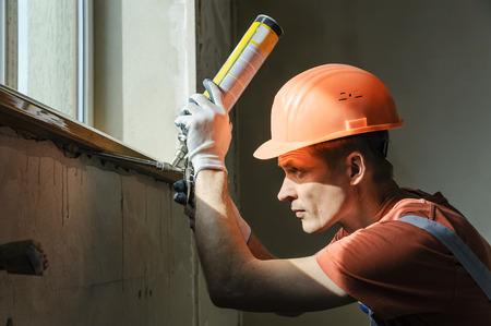 Worker is using a polyurethane foam for installation of window sill.の写真素材