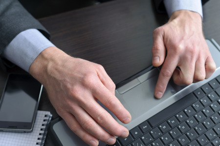 Businessman hands  doing some computer work , finger on touchpadの写真素材
