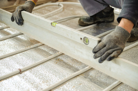 Man sets flat concrete floor with a ruler and spirit level