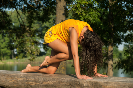 Beautiful young woman performing yoga exercises on the lake.の写真素材