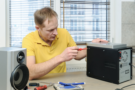  The man is using a screwdriver to open the music system.の写真素材