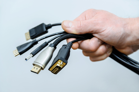 There are various cords and plugs in the hand of a man.の写真素材