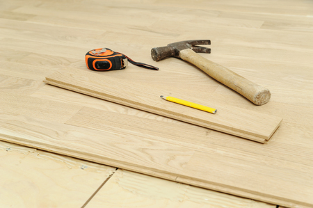Laying hardwood parquet. Hammer, pencil, measuring tape or flooring.の写真素材