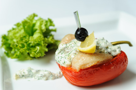 Red peppers stuffed with meat in white sauce.の写真素材