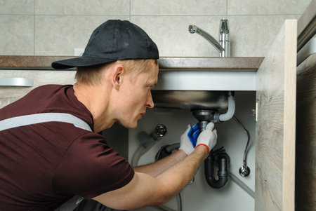  Worker sets trap for kitchen sink.の写真素材