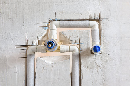 The concealed faucet with connected pipes is mounted in the wall.