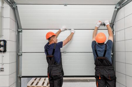 Workers are installing lifting gates of the garage.の写真素材