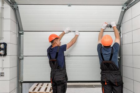 Workers are installing lifting gates of the garage.