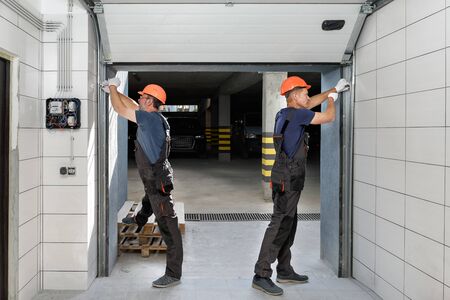 Workers are installing lifting gates of the garage.の写真素材