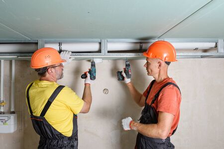 Installation of drywall. Workers are mounting the plasterboard with a vent hole. の写真素材