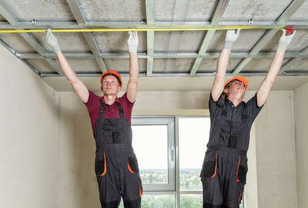 Installation of drywall. Workers are measuring the ceiling.の写真素材