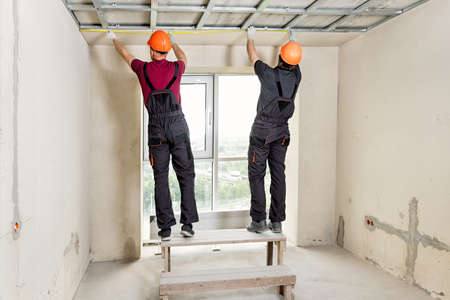 Installation of drywall. Workers are measuring the ceiling.の写真素材