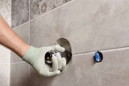 The worker's hand is mounting a built-in faucet.の写真素材